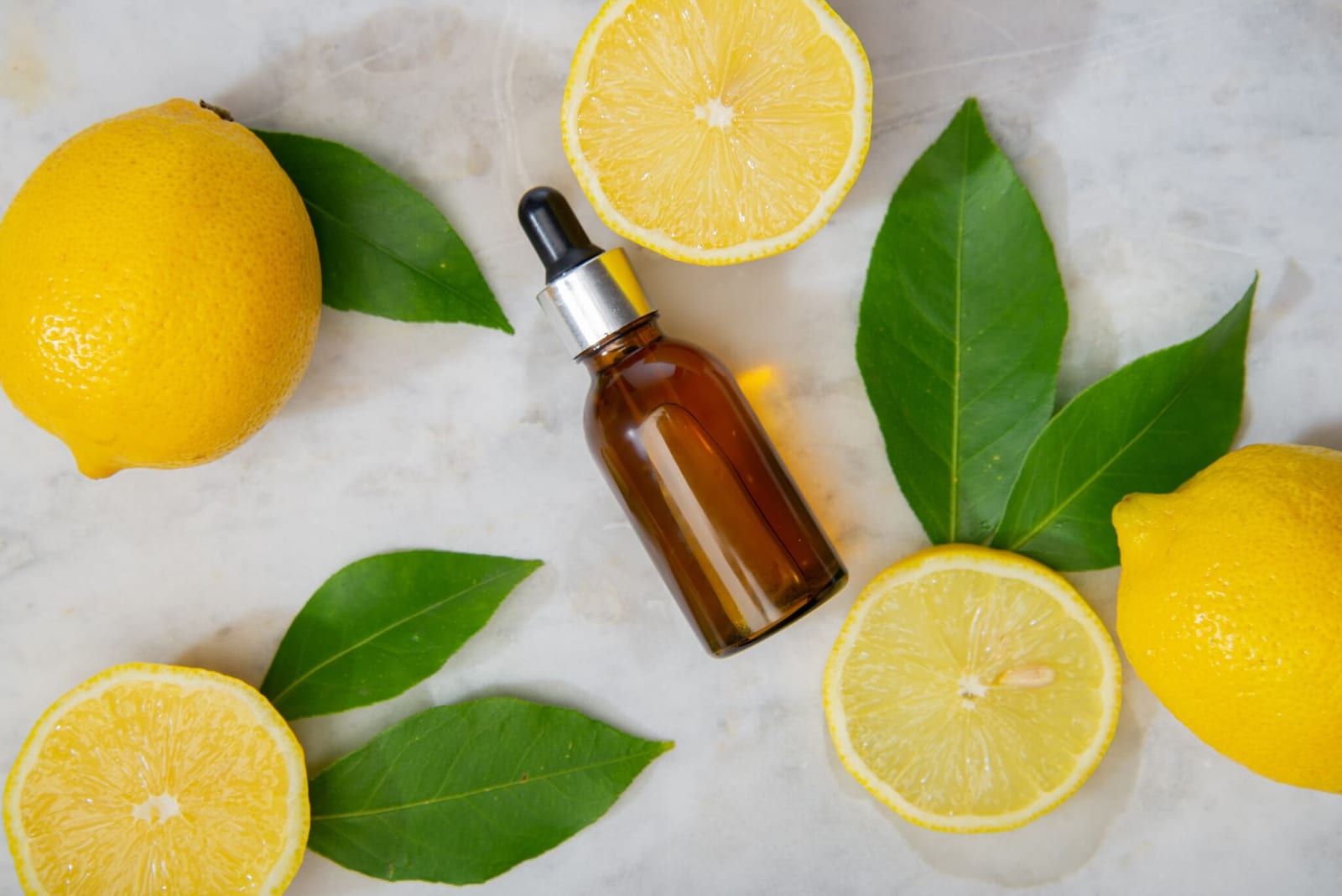botlte of lemon essential oil used to help with congestion and stuffy nose surrounded by lemon slices