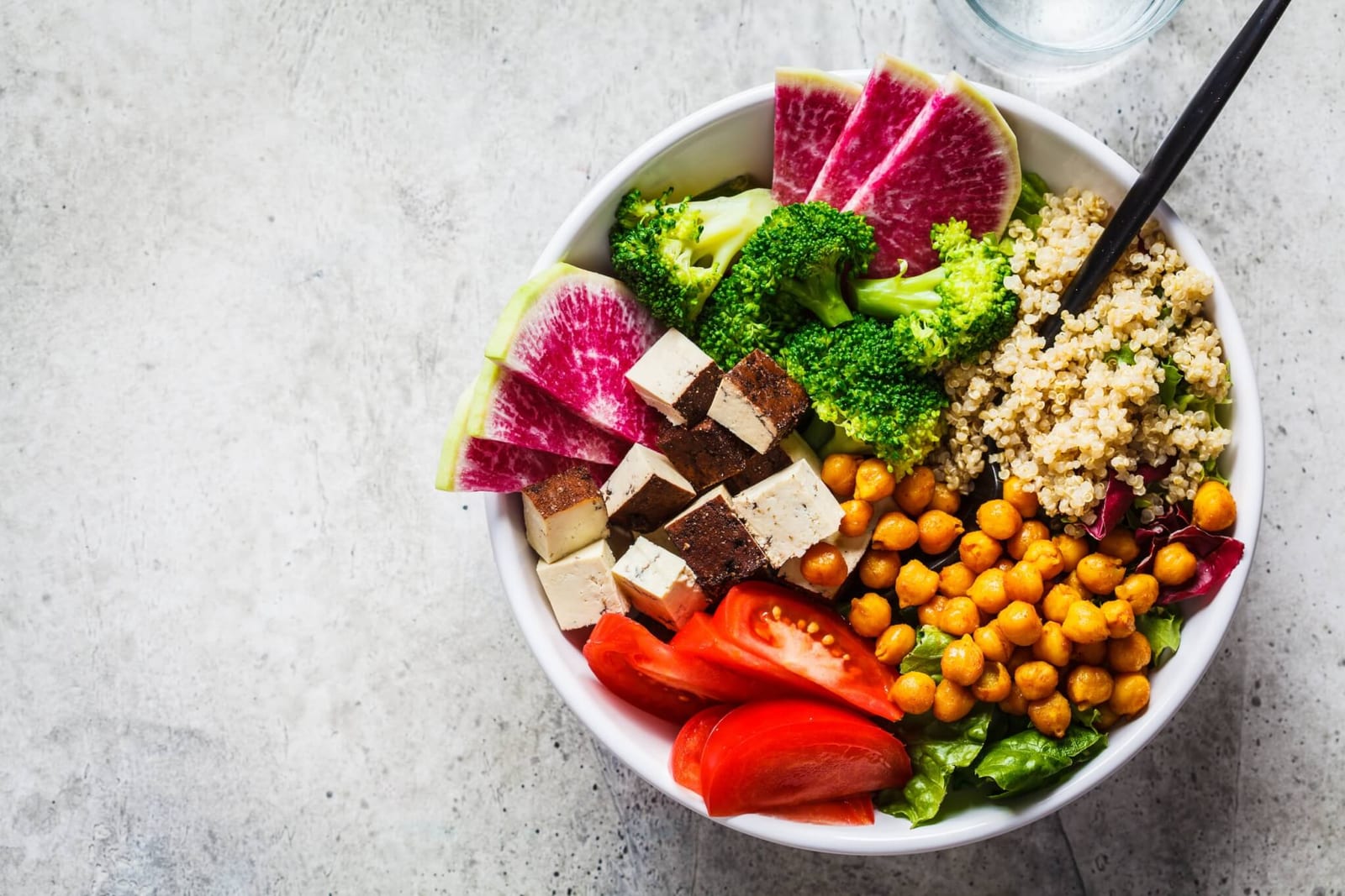 high fiber tofu and chickpea bowl featuring a collection of fruits and vegetables as part of a healthy diet for colon health