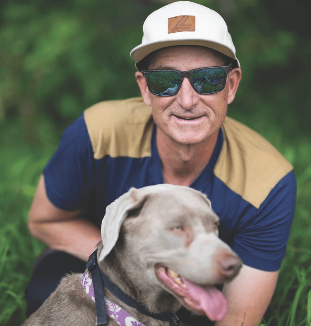 man in a baseball cap and sunglasses with his dog