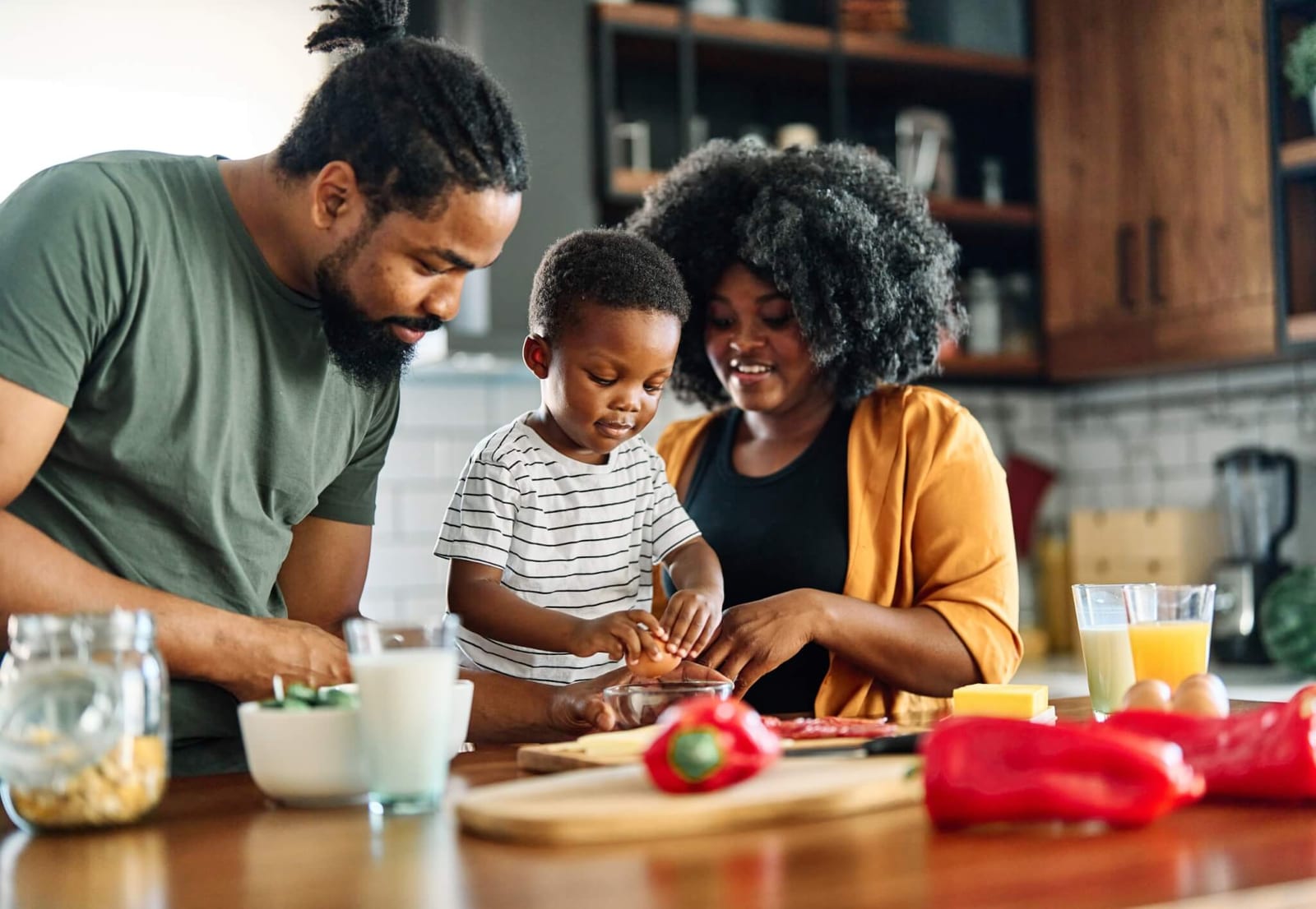 mother and father teaching their young child how to cook