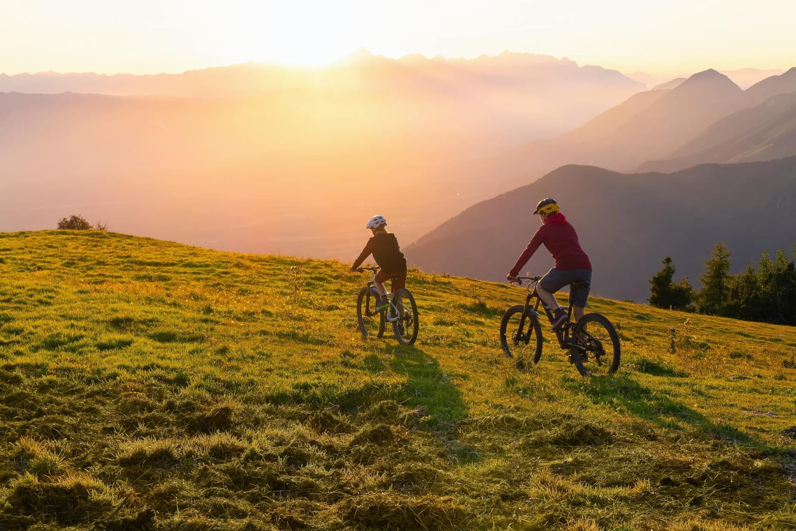two people who are of age for crc colon cancer screening testing biking through the mountains at sunset