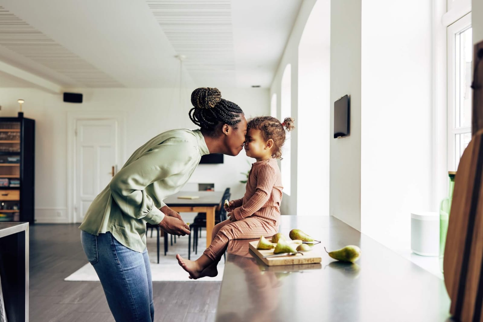 woman who meets the new age guidelines for colon cancer screening playing with her toddler in the kitchen