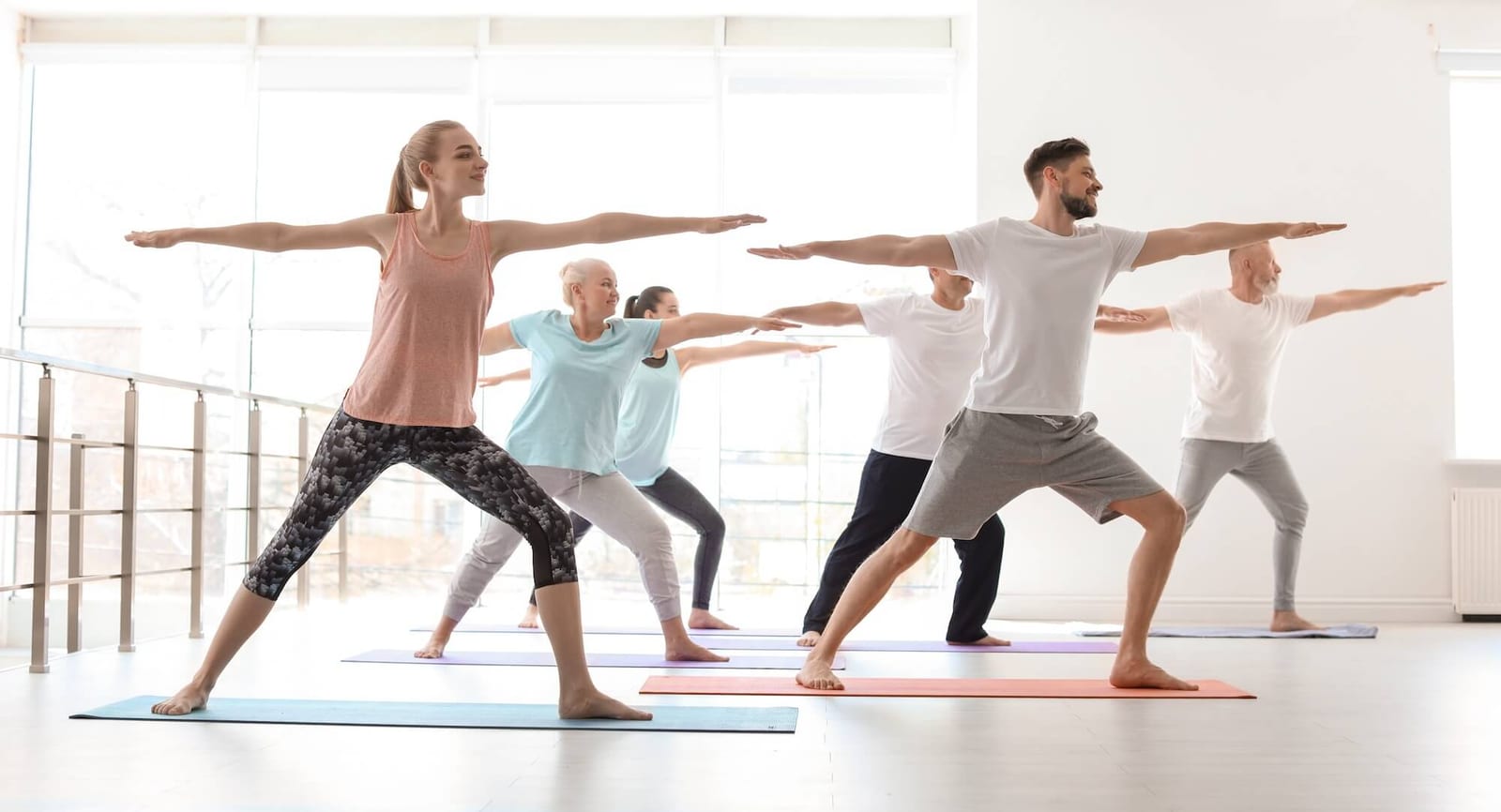 Group of people in sportswear practicing yoga indoors