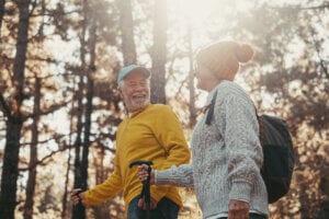 Portrait close up head shot of one cheerful smiling middle age woman walking with her husband enjoying free time and nature. Active beautiful seniors in love together at sunny day - how nature can provide stress relief