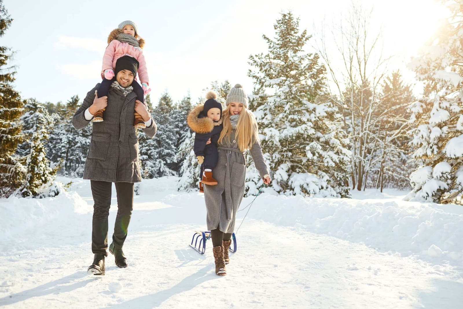 family with young kids walking through a snowy winter landscape so they can experience the effects of light therapy on anxiety and seasonal affective disorder