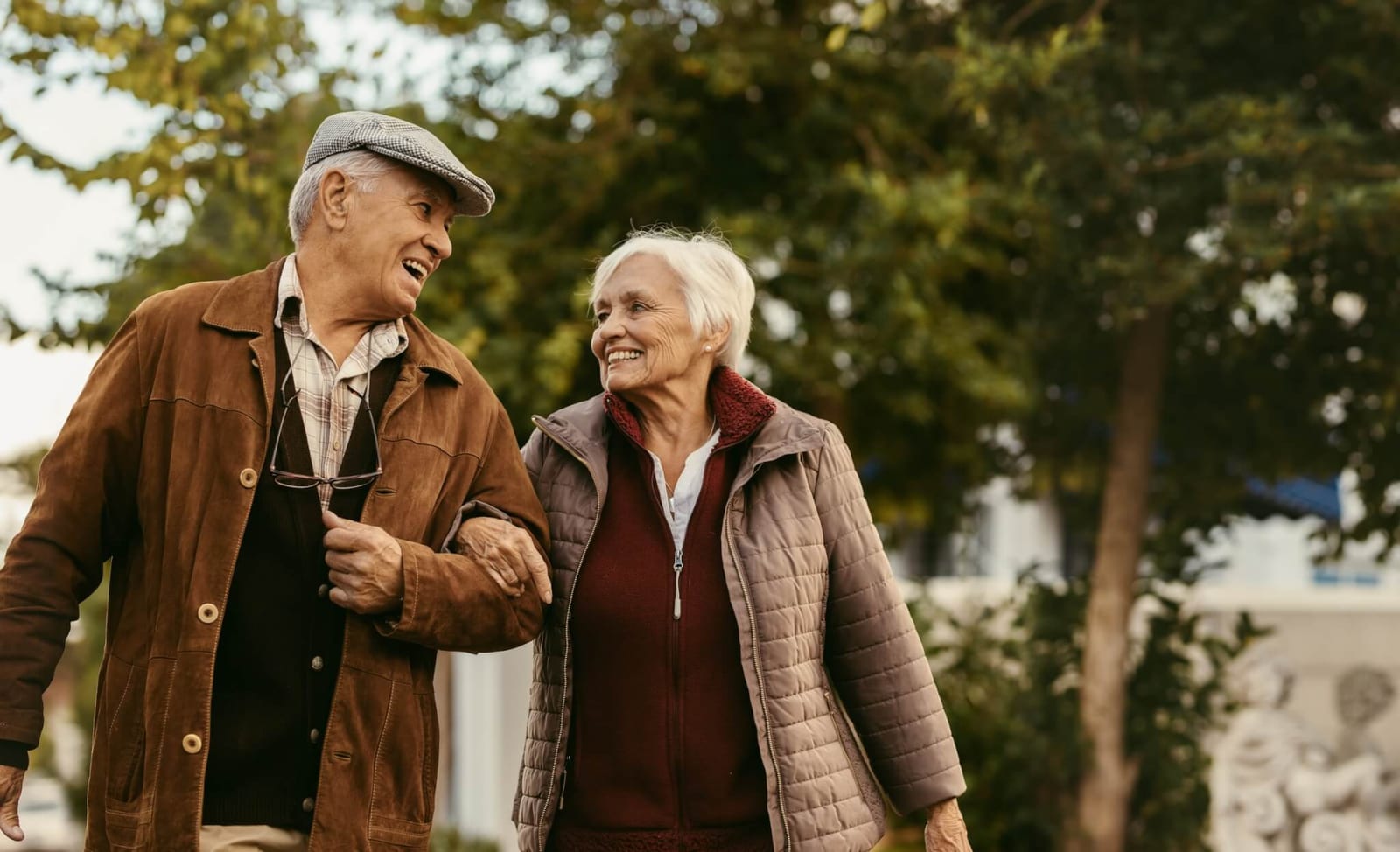 couple linking arms and walking through a park as a way to use light therapy for their symptoms of anxiety