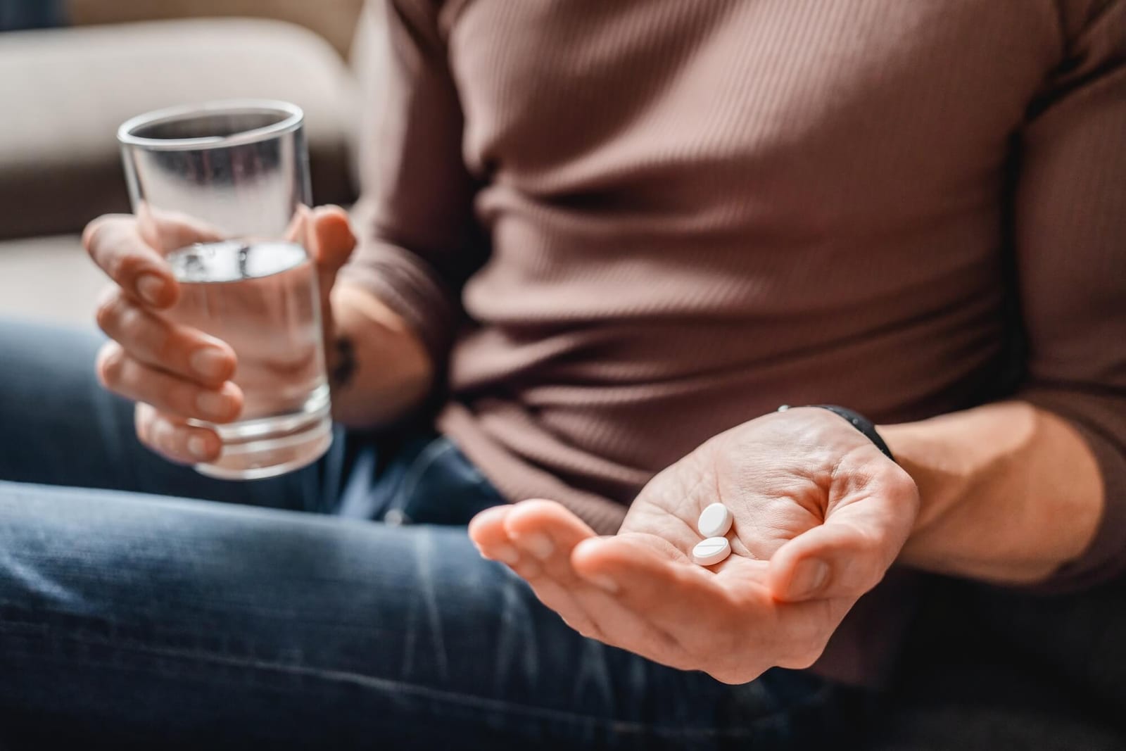 Close up of man taking medicines with water men's hormones