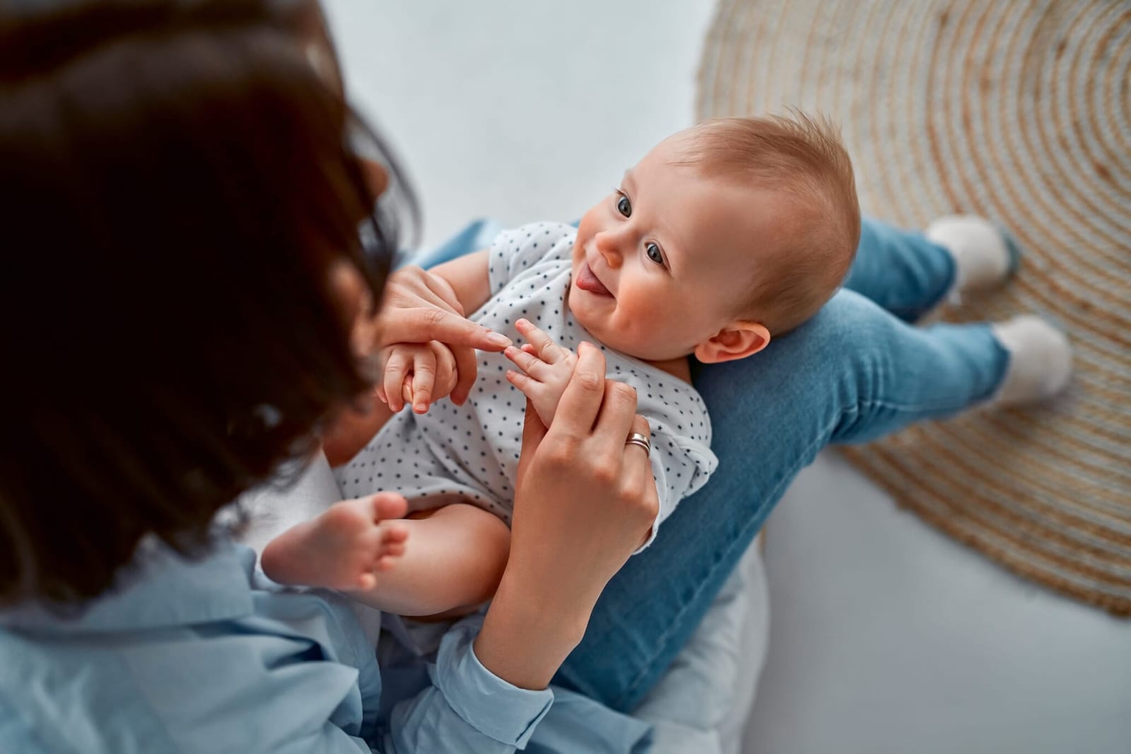mom who has postpartum brain fog holding the hands of her infant