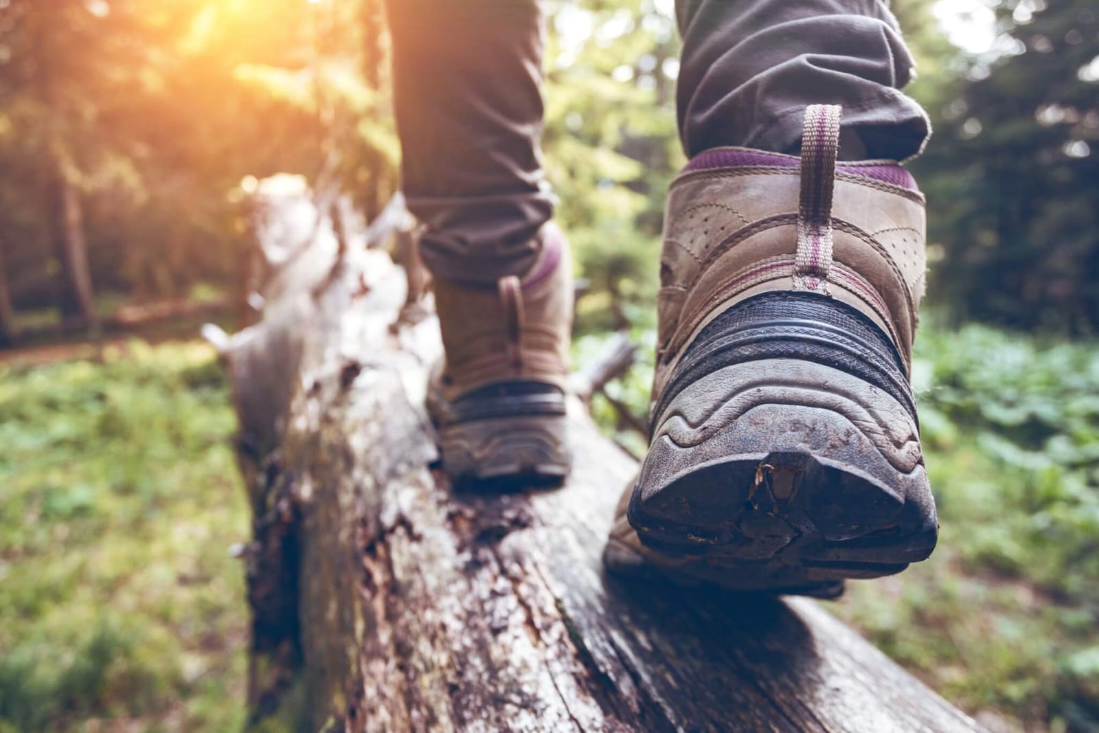 close up of feet in well-fitting hiking boots walking on a log