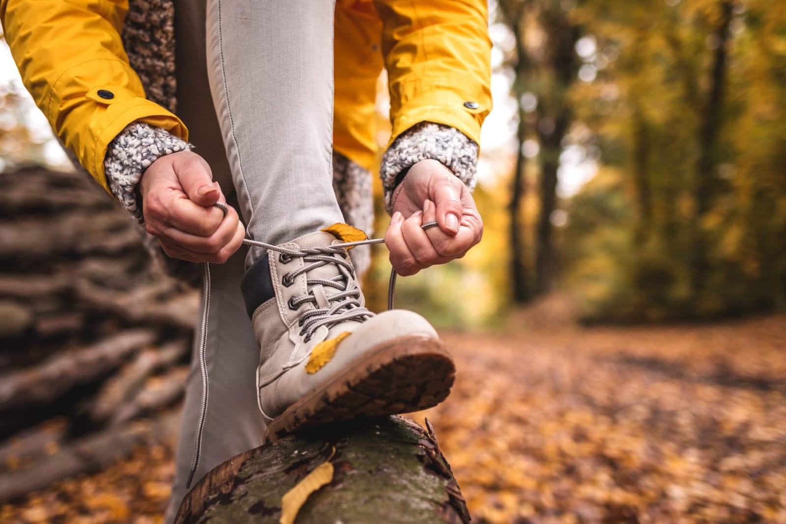 woman tying her hiking boots to ensure they fit correctly so she can avoid getting blisters while hiking