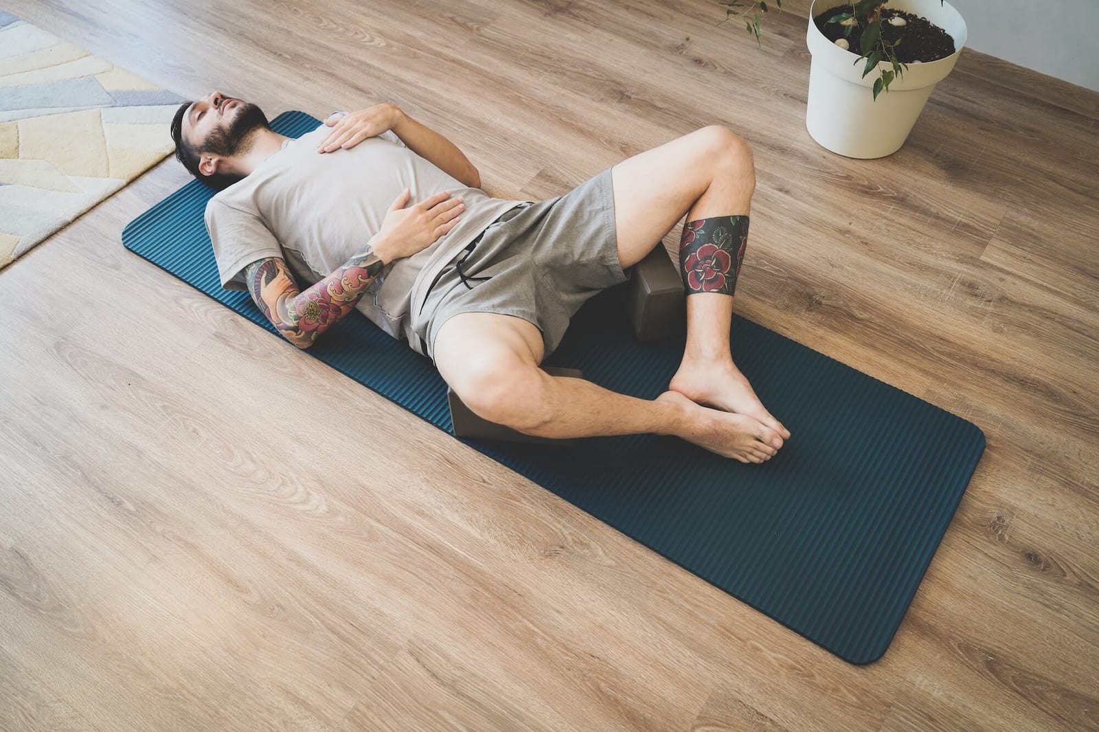 Tired Young man lying on a yoga mat after workout. Man practicing yoga and meditation at home. A series of yoga poses. Lifestyle concept