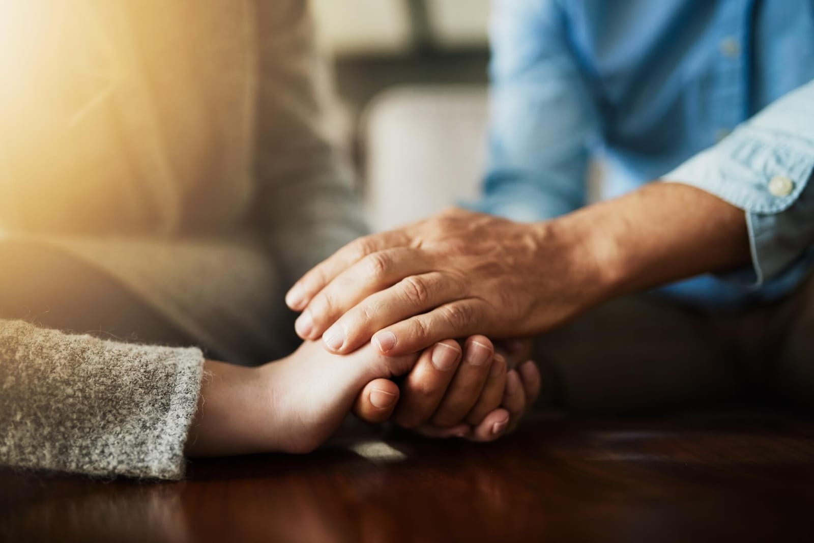 two sets of hands holding each other, one older and one younger