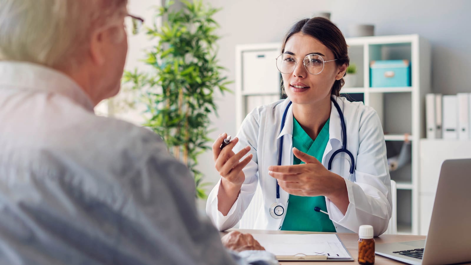 Female doctor and senior male patient discussing at clinic