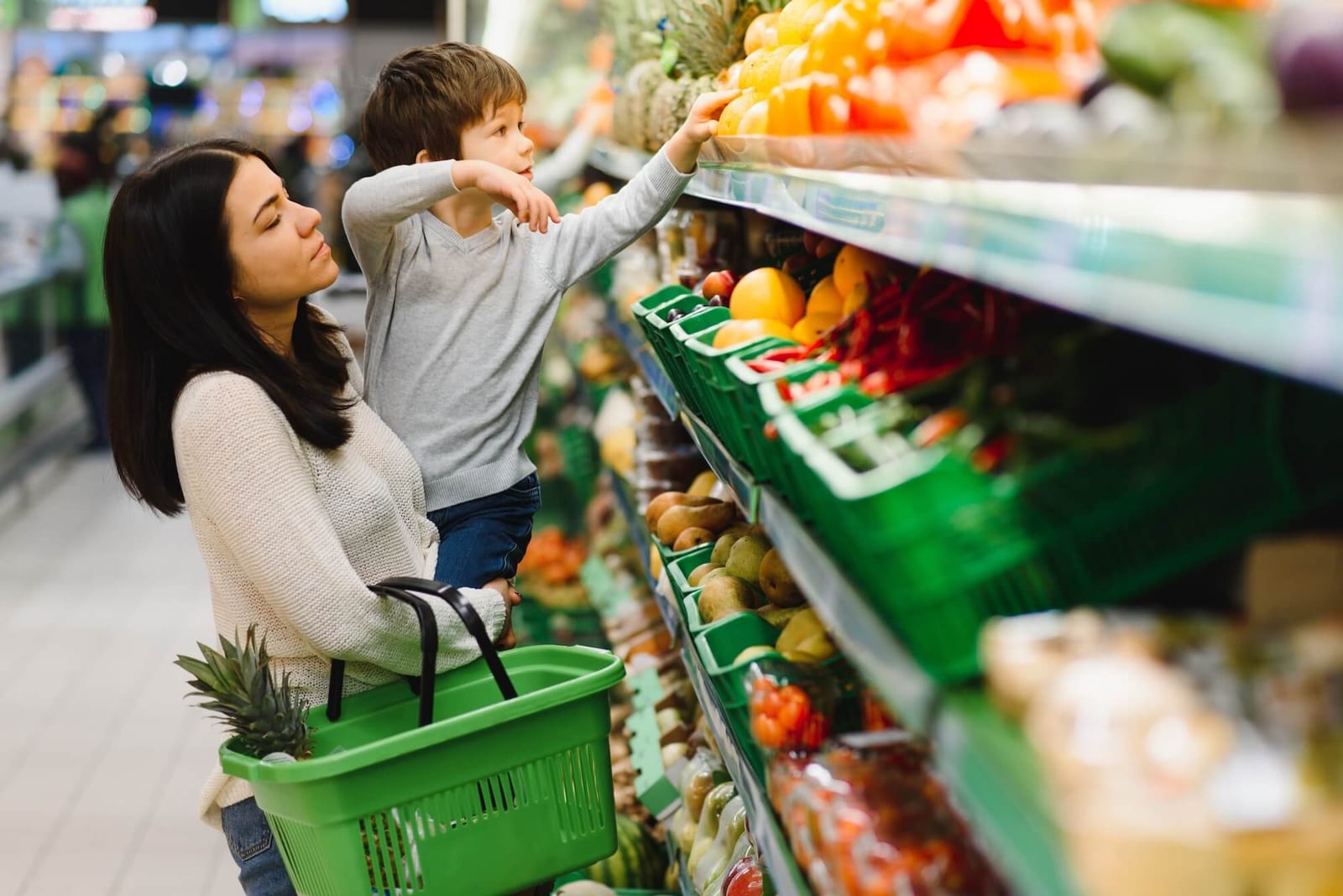 Young mother with her little baby boy at the supermarket. Healthy eating concept