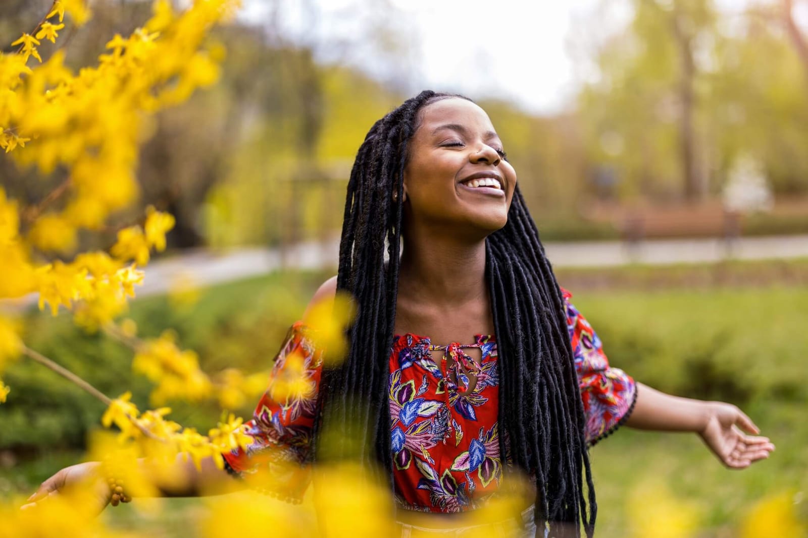 woman closing her eyes and holding her hands out and smiling