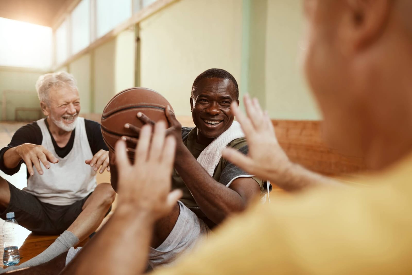 man who has chosen to live in an independent senior living and retirement community playing basketball with his friends